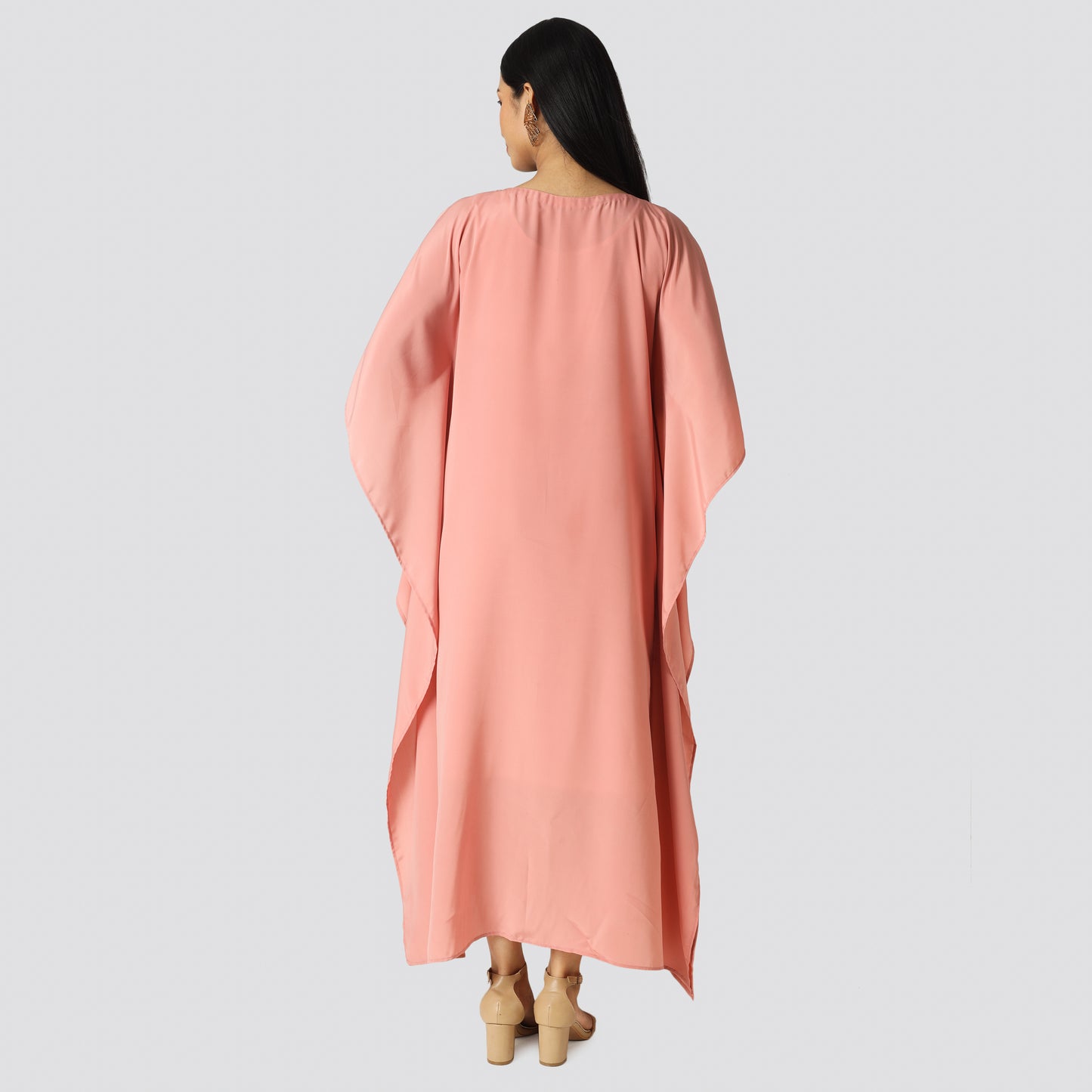 A lady wearing pink kaftan and showing dress backside