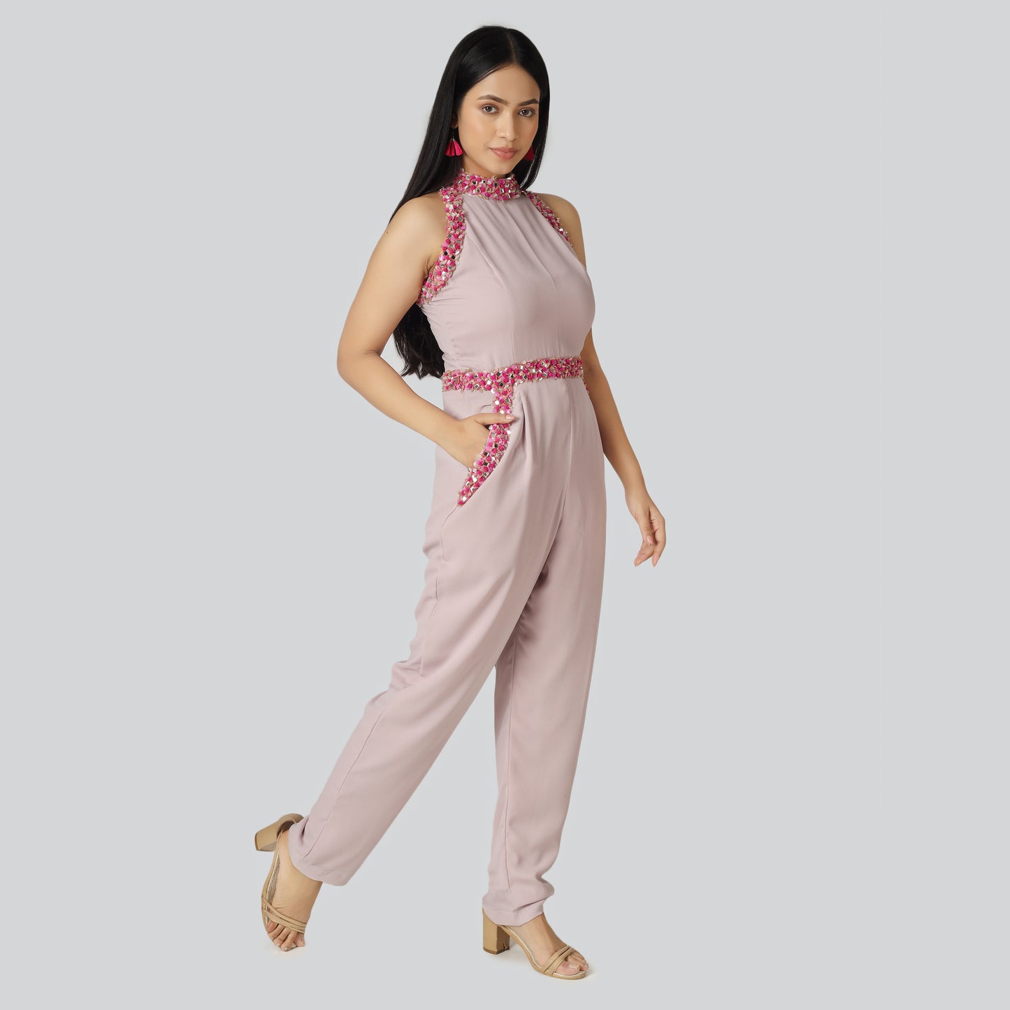 Lady in pink jumpsuit dress putting her on hand in pocket