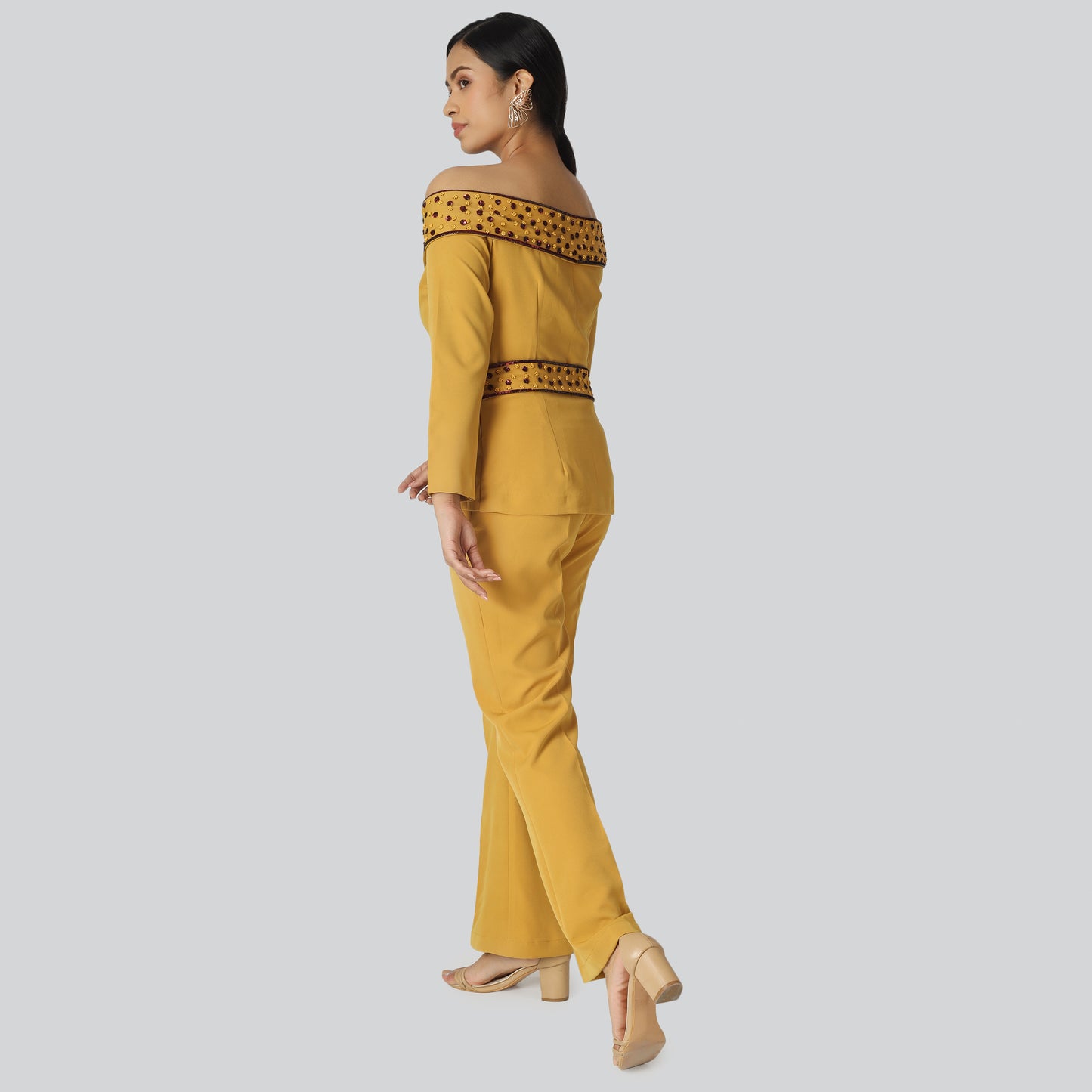 A girl wearing off shoulder mustard pant suit